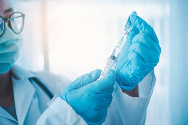 Şırıngalı doktor hastaya aşı yapmaya hazır. Aşılama kavramı.