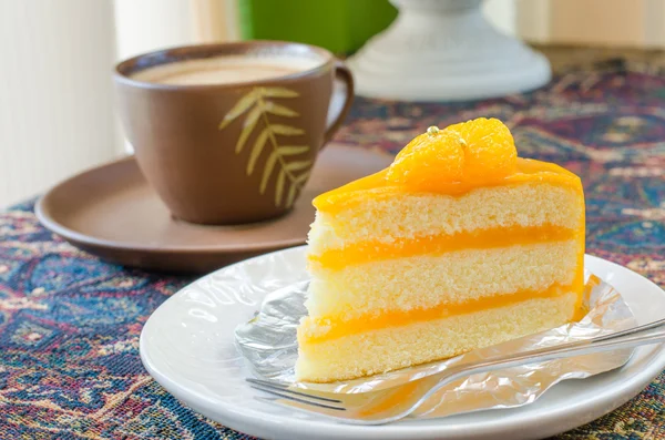 Oranje cake en laat koffiekopje — Stockfoto