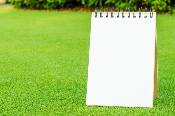 Notebook na svěží jarní zelené trávě — Stock fotografie