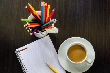 defter pencill ve ahşap masa kahve fincan
