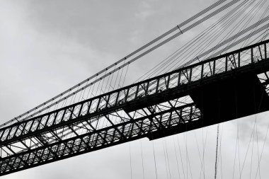 Newport Taşıyıcı Köprüsü 'nün Newport' ta 1902 yılında inşa edilen bir bölümünün siyah ve beyaz yakın plan görüntüsü Newport 'ta Usk Nehri' ni geçer ve birinci sınıf olarak listelenmiş bir yapıdır, ana kiriş kirişi 232 metre uzunluğundadır.