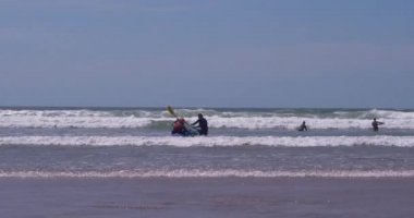 Gower Yarımadası Galler 'deki Llangennith Sahili' nde deniz kanosu. Llangennith Sahili, Gower Yarımadası, Galler. Sörf ve macera dolu su sporları aktiviteleriyle çok popüler bir plaj. Sağlıklı yaşam tarzı olanlar için mükemmel bir yer..
