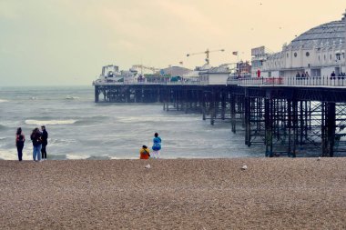 Brighton İskelesi, aynı zamanda Palace Pier olarak da bilinir, 1899 'da inşa edilen tarihi öneme sahip popüler bir turizm merkezi. Hava fırtınalı ve yüzmek yasak.