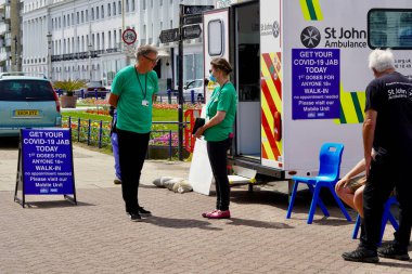 Eastbourne, Doğu Sussex, İngiltere - 3 Temmuz 2021: St John 's Ambulansı ve NHS, Eastbourne' daki gezinti alanında 18 yaşın üzerindeki herkese Covid 19 aşı öneriyor