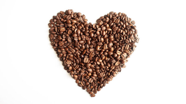 Coffee beans laid out in the shape of a heart on a white background.