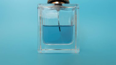 Mavi arka planda bir şişe parfüm.