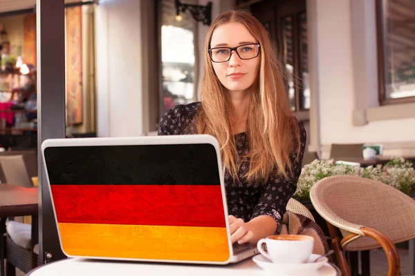 Donna seduta in caffetteria con taccuino con bandiera tedesca — Foto Stock