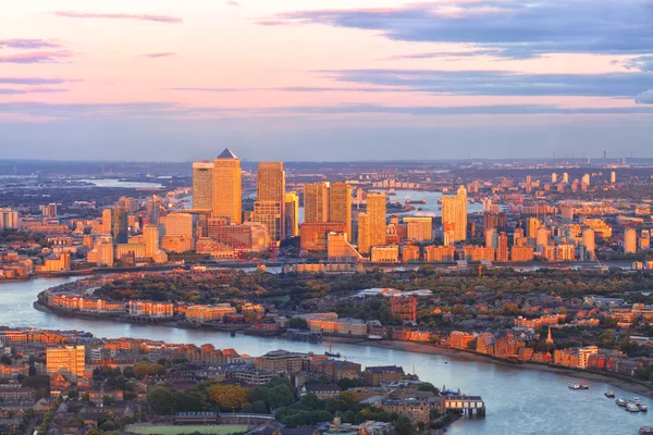 Havadan görünümü, Doğu Londra mali bölge, Canary Wharf renkli günbatımı tarafından aydınlatılmış binalar ile Thames Nehri tarafından daire içine alınmış Docklands