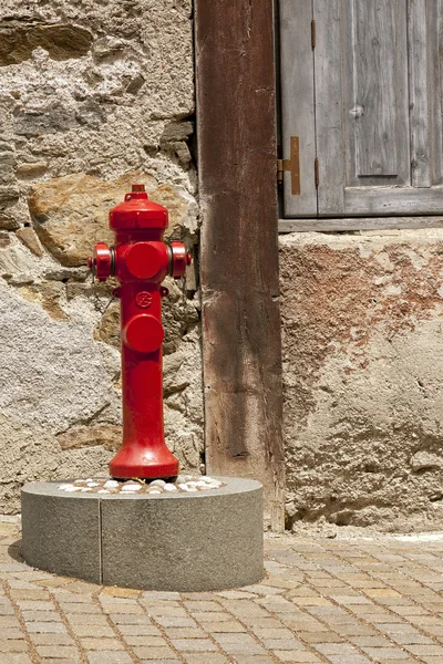 Hidrante de fogo vermelho em uma rua de pedra — Fotografia de Stock