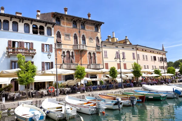 Desenzano, Garda Gölü, Brescia, İtalya, 5 Haziran 2012: açık havada yemek ve şirin kafe ve restoranlar ile küçük bir liman tarafından içme demirlemiş balıkçı tekneleri