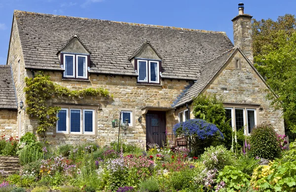 Ancien chalet traditionnel anglais miel doré marron lapidé avec jardin de fleurs de colorfu sur un jour ensoleillé d'été — Photo