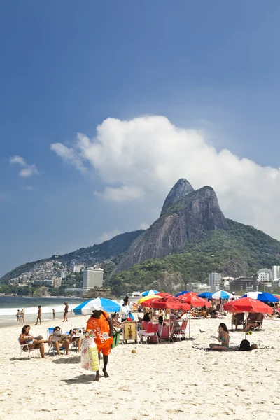 Vida de playa en Ipanema Rio de Janeiro personas relajándose bajo sombrillas sentadas en tumbonas —  Fotos de Stock