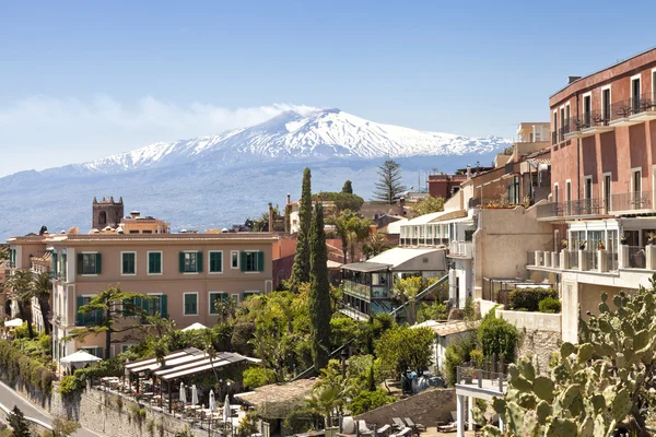 Vista panorâmica da histórica cidade siciliana de Taormina, no fundo com pico branco do vulcão Etna com fumaça no dia da primavera quente — Fotografia de Stock