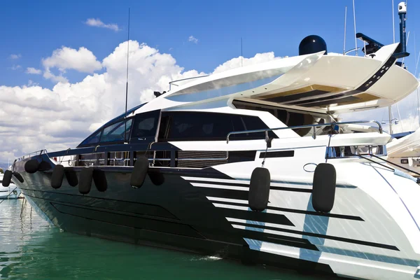 Moderní luxusní motorová jachta v bílé a tmavě modré barvy, kotvící v přístavu moře. — Stock fotografie