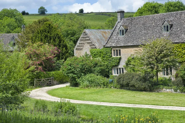 Estrada arenosa em uma aldeia rural com antigas casas de pedra inglesas tradicionais em um vale verde — Fotografia de Stock