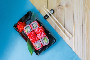 Mavi arka planda bir suşi ve maki seti. Kopyalama alanı olan üst görünüm.