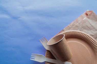 Tek kullanımlık çevre dostu gıda ambalajı. Leylak kaplamalı kahverengi kraft kağıdından yapılmış yiyecek kapları. Üst manzara, düz uzanma.