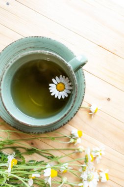 Papatya çayı, ahşap bir arka planda papatya çayı. Bir fincan papatya çayı..