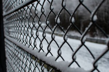 Donmuş ve karla kaplı bir tel örgü.