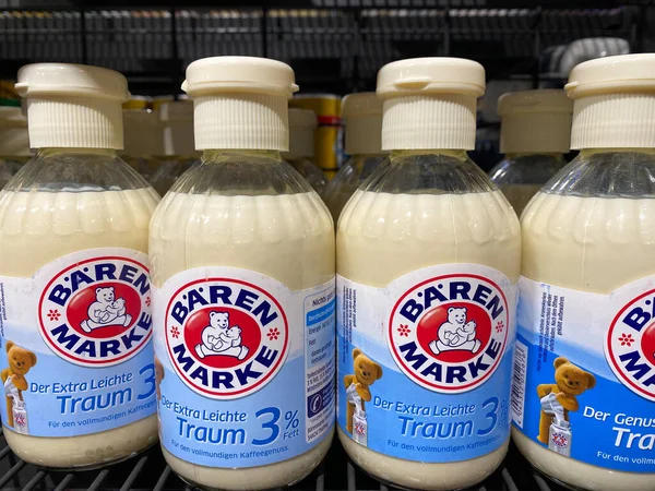 Bir süpermarketin rafında% 3 yağlı birkaç şişe 