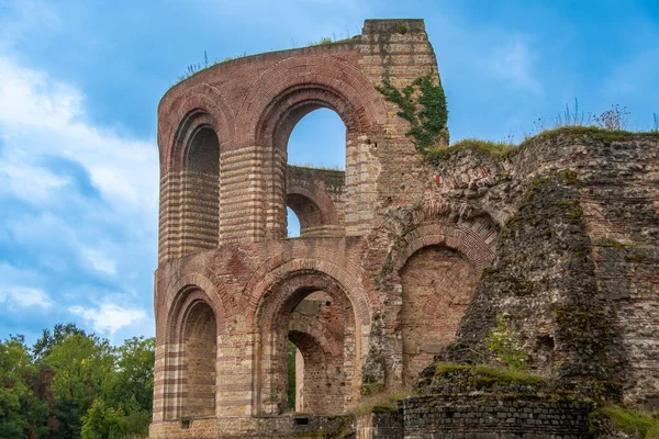 İmparatorluk hamamlarının kalıntıları, mavi gökyüzüne karşı korunmuş tuğla kemerler ve tarihi duvarlar.