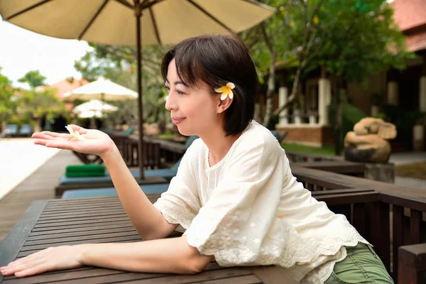 Mujer con frangipani — Foto de Stock