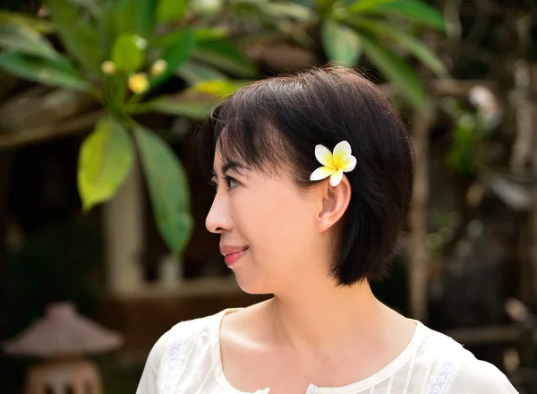 Femme avec frangipani — Photo