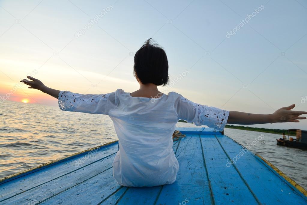 Woman doing yoga by wood boat