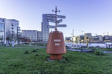 Bir zamanlar Dublin, İrlanda 'da Liffey ve Dodder nehirlerinin birleştiği yer olan Dodder Şamandırası. Dünya üzerindeki birçok yerin yönünü ve mesafesini gösteriyor..  
