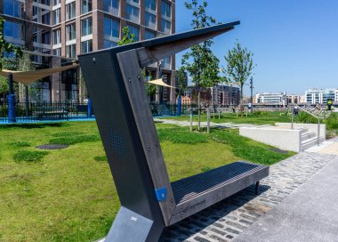 Hanover Quay, Dublin, İrlanda 'da halka açık bir koltuğa kurulmuş güneş enerjili bir cep telefonu şarjı.. 
