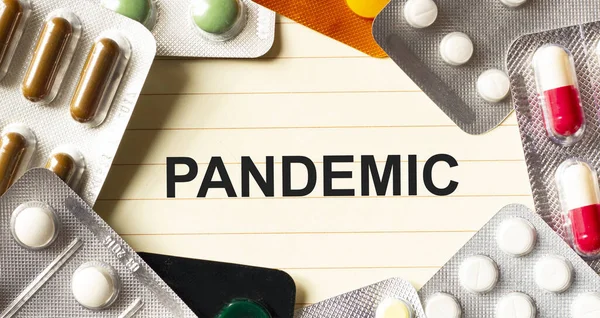 白い背景にPandemicという文字 周辺には様々な薬があります 医学的概念 — ストック写真