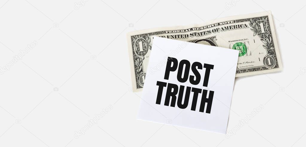 1 dollar bill and white notepad sheet on the white background. POST TRUTH text.