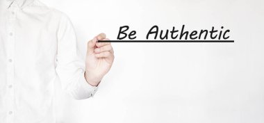 Saydam silme tahtasında siyah kalemle AUTHENTIC yazmakta olan işadamı