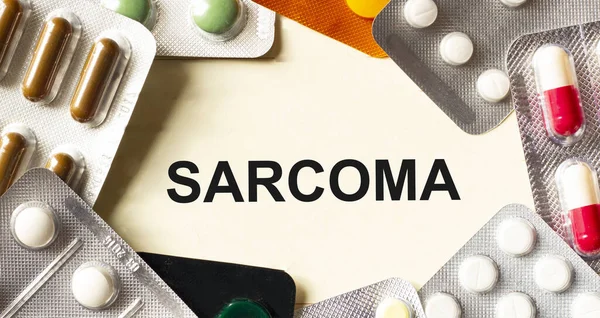Texto Sarcoma Sobre Fondo Blanco Muy Cerca Hay Varios Medicamentos — Foto de Stock