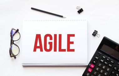 İş konsepti. Not defteri notlar, hesap makinesi, gözlük, kalem, kalem, beyaz arkaplan için AGILE beyaz kağıt sayfa