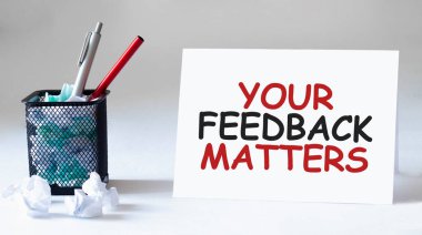 Boş çarşaf, kalem ve buruşuk kağıt toplar gri masada, düz yatıyordu. FEEDback Maddelerine Mesaj at