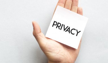 Pembe gömlekli bir iş adamının elinde kağıt kartvizit var. Üzerinde özel yazı var. Beyaz arka planda izole edilmiş yakın plan.