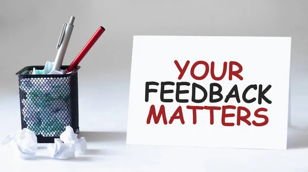 Boş çarşaf, kalem ve buruşuk kağıt toplar gri masada, düz yatıyordu. FEEDback Maddelerine Mesaj at