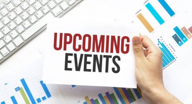 İş adamı elinde yaklaşan olaylarla ilgili bir kart tutuyor. Klavye, diyagram ve beyaz arkaplan