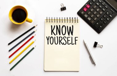 Kahve fincanı, hesap makinesi, not defteri, beyaz arka planda kalem ve kalemler. İş konsepti. SİZİN BİLGİLİR