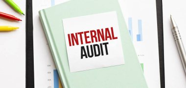 Beyaz, büyük not defteri, yeşil kitap ve kâğıt tabaka üzerinde mali diyagram. İş konsepti