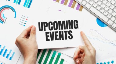 İş adamı elinde yaklaşan olaylarla ilgili bir kart tutuyor. Klavye, diyagram ve beyaz arkaplan