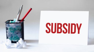 Boş çarşaf, kalem ve buruşuk kağıt toplar gri masada, düz yatıyordu. Metin Alt Tarafı