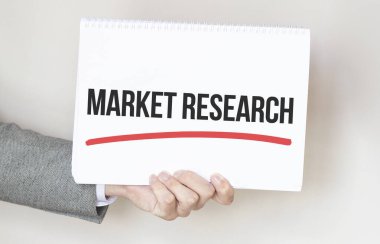 Üzerinde MARKET REARCH yazan bir kart tutan işadamı