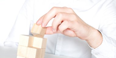 Tahta blokları istifleyen bir adam. İş geliştirme kavramı.