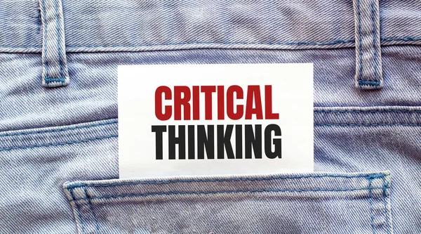 Critical thinking words on a white paper stuck out from jeans pocket. Business concept