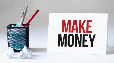 Boş çarşaf, kalem ve buruşuk kağıt toplar gri masada, düz yatıyordu. Metin para kazandırır