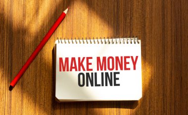 Metni olan kırmızı kalem ve not defteri beyaz arkaplanda çevrimiçi para kazandırıyor