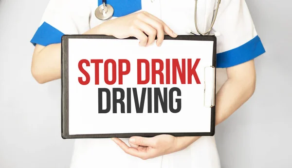 Doctor holding a card with text STOP DRUNK DRIVING, medical concept