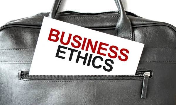 Text BUSINESS ETHICS writing on white paper shit in the black business bag. Business concept